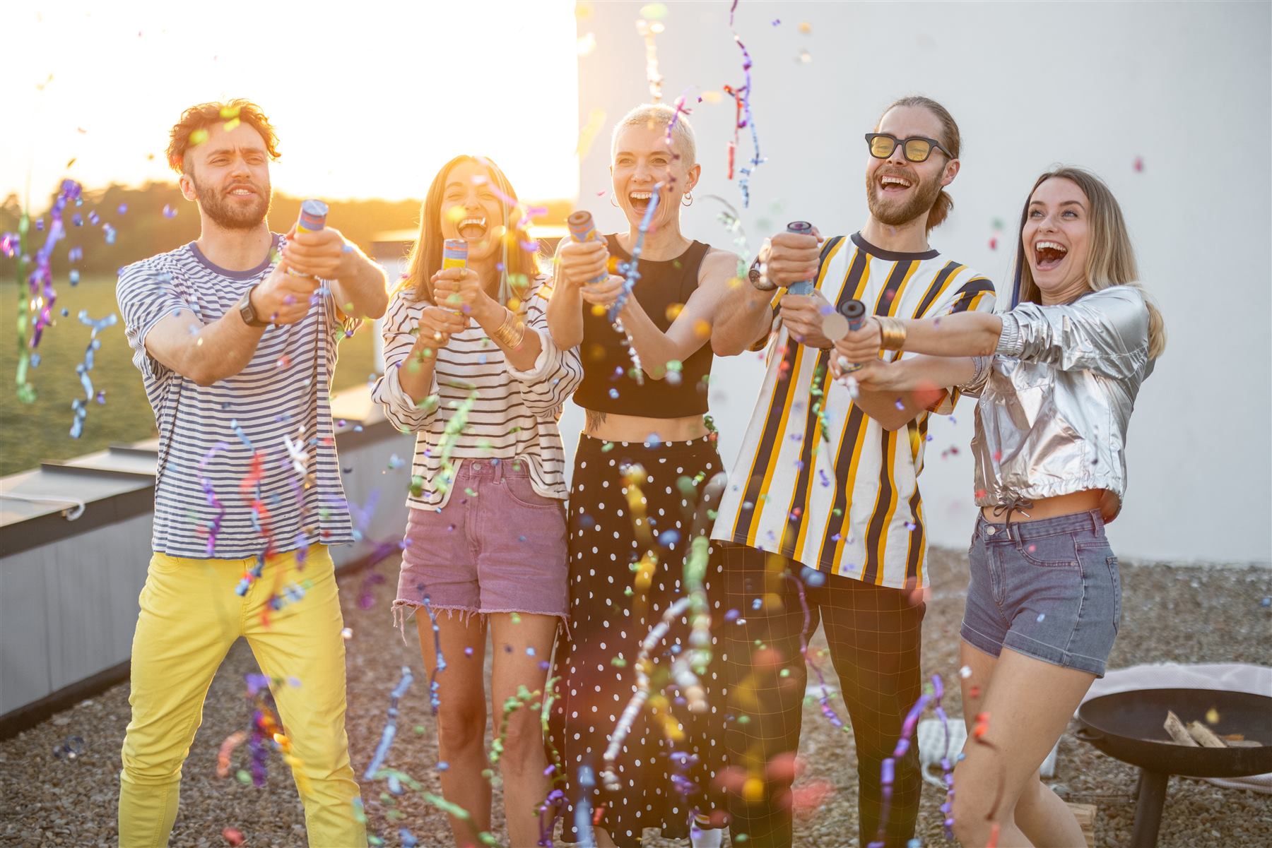 Un gruppo di amici festeggia insieme con coriandoli, sorridenti