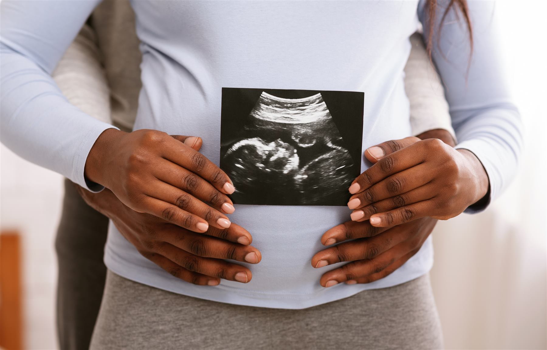 Una coppia guarda insieme l'immagine di un'ecografia, sorridenti